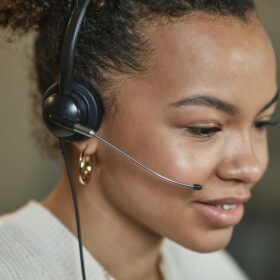 Close-up of a focused call center agent wearing a headset, working indoors.